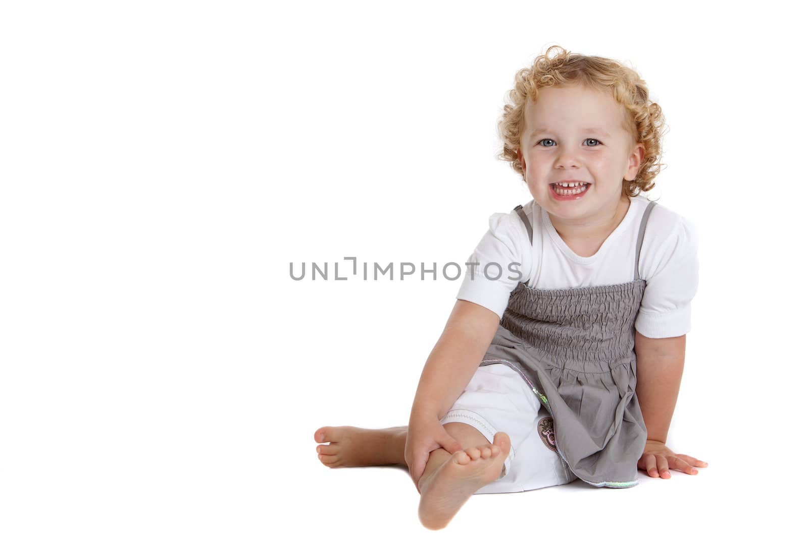 Cute three year old girl sitting on the floor on white background