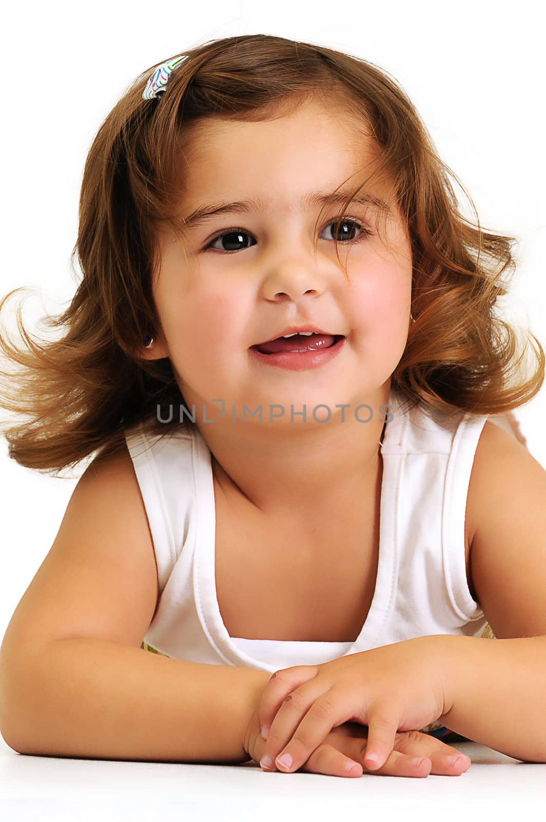 Little girl looking and smiling whilst leaning on her arms by Ansunette