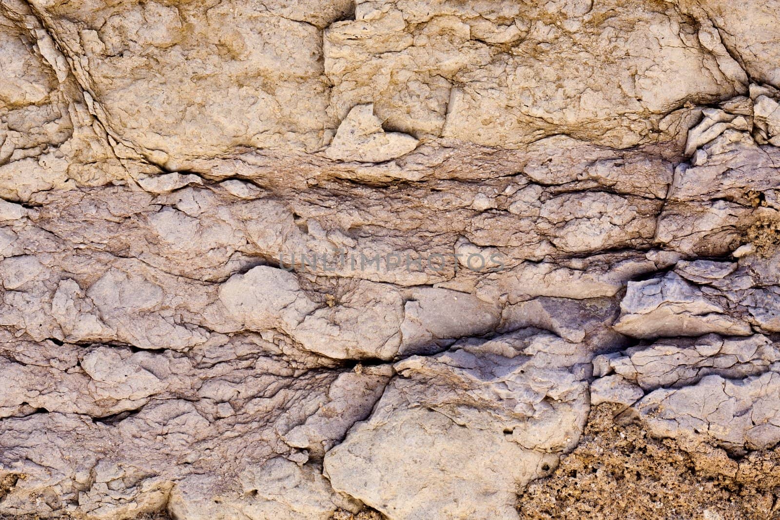 Close up view of a worn textured stone wall.