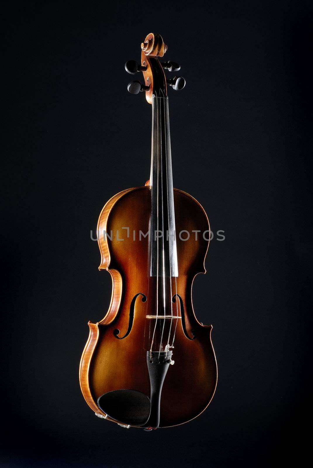 Old violin against black background