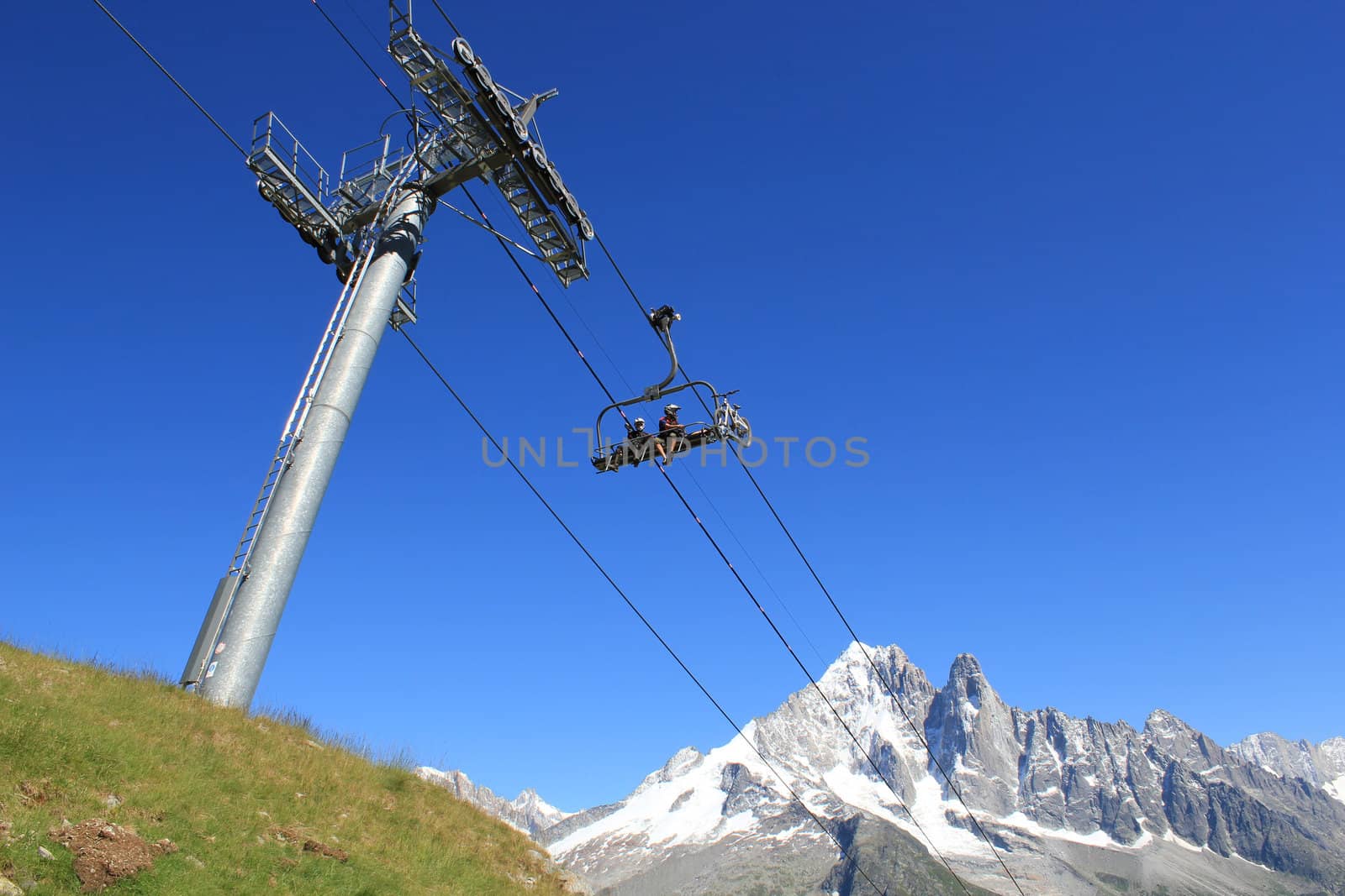 Bikers on a chairlift in the mountain by Elenaphotos21
