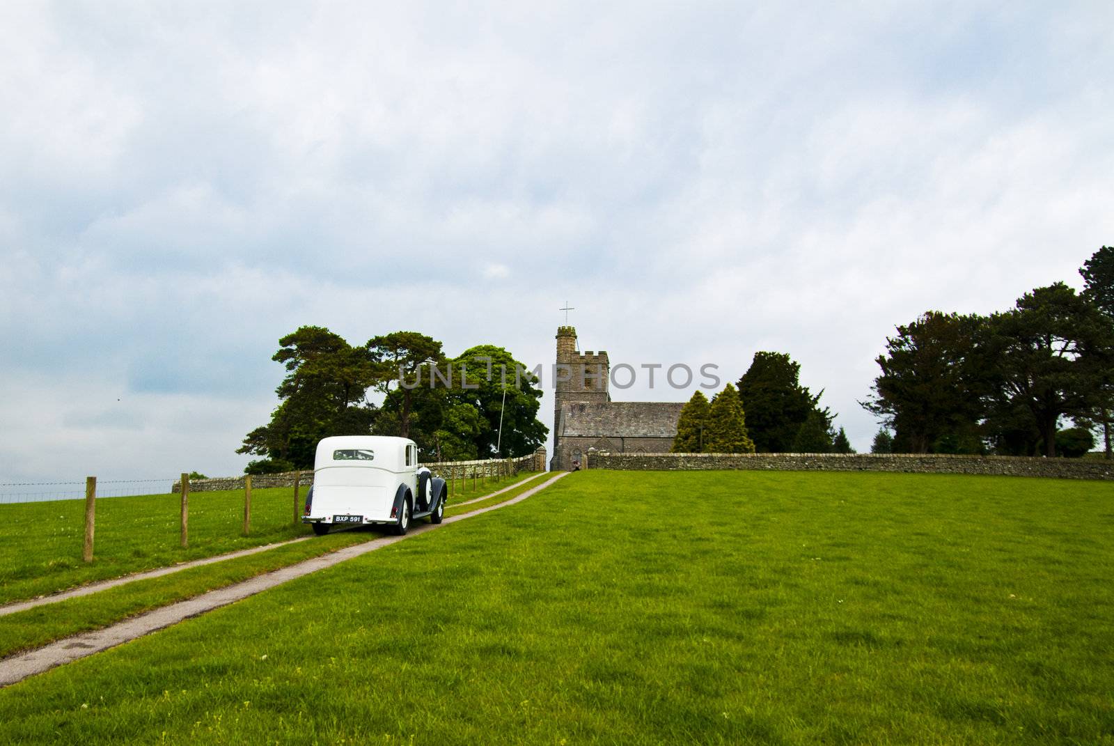 vintage wedding car approaching small rural church