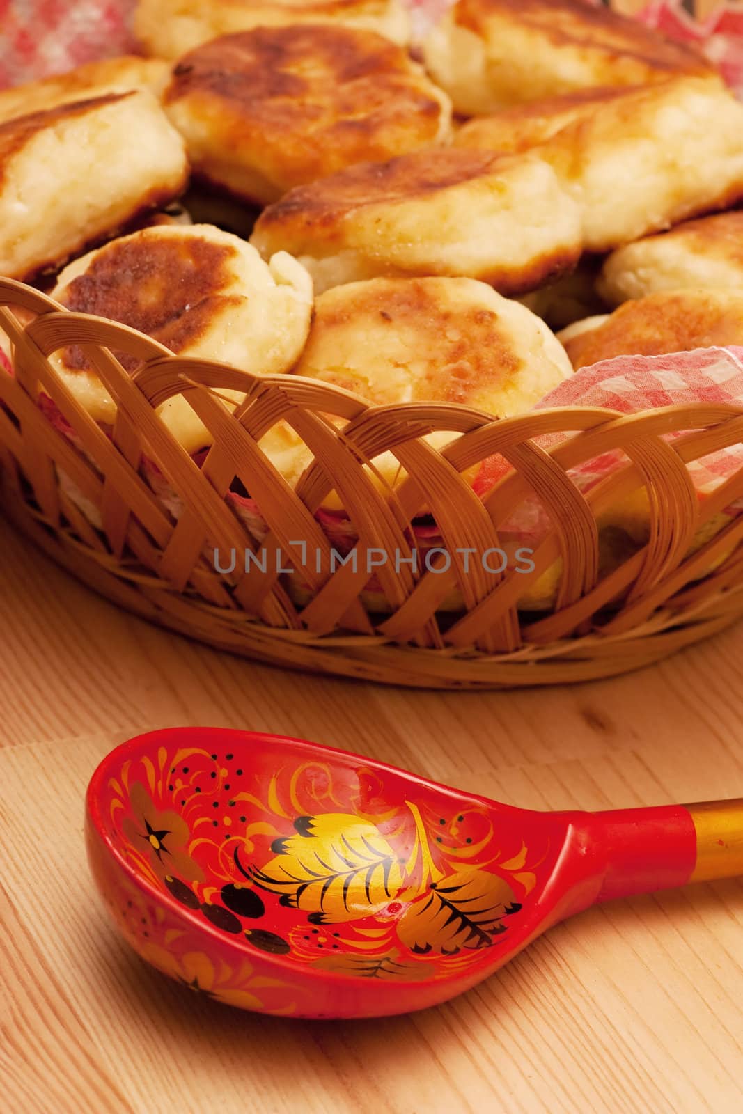 Curd pancakes and decorated spoon on a wood table