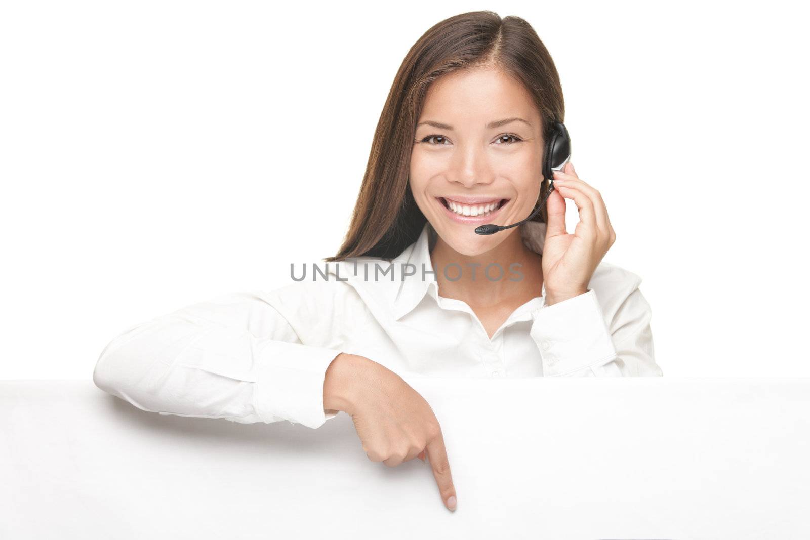 Customer Service woman with headset showing and pointing at blank billboard sign banner, Young smiling Chinese Asian / Caucasian female model.