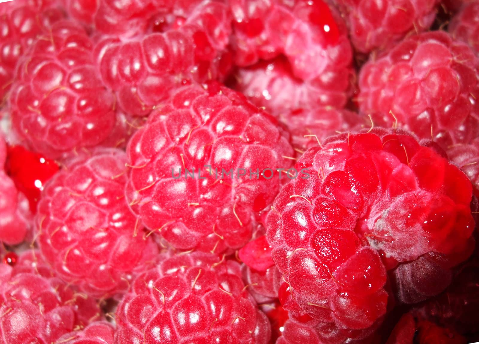 A close-up of a punnet of juicy pink raspberries