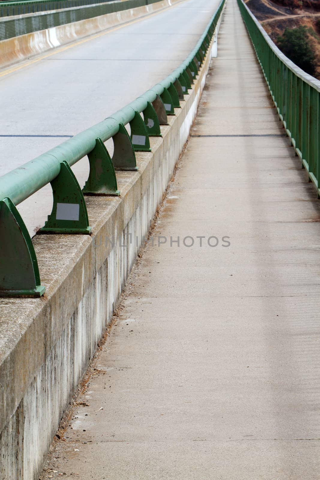 Road and pedestrian walk on bridge with green metal gaurd rails