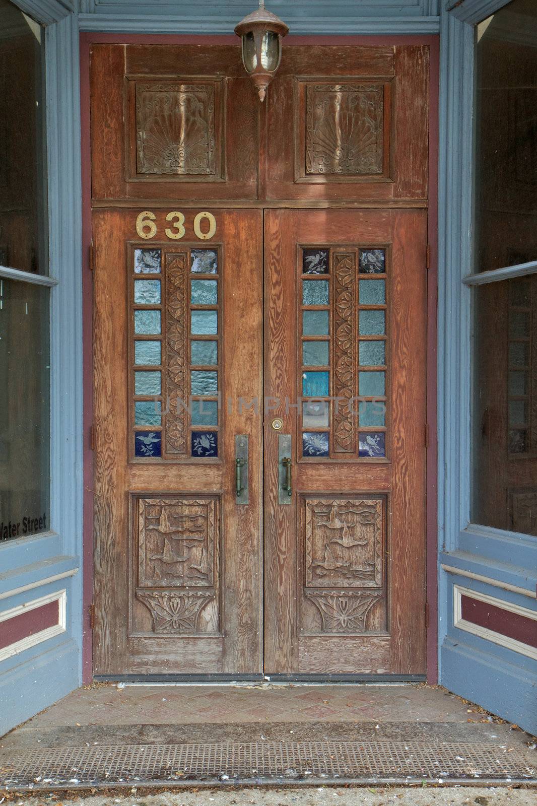 Old worn and weathered wood door with duck and bird carvings and etching