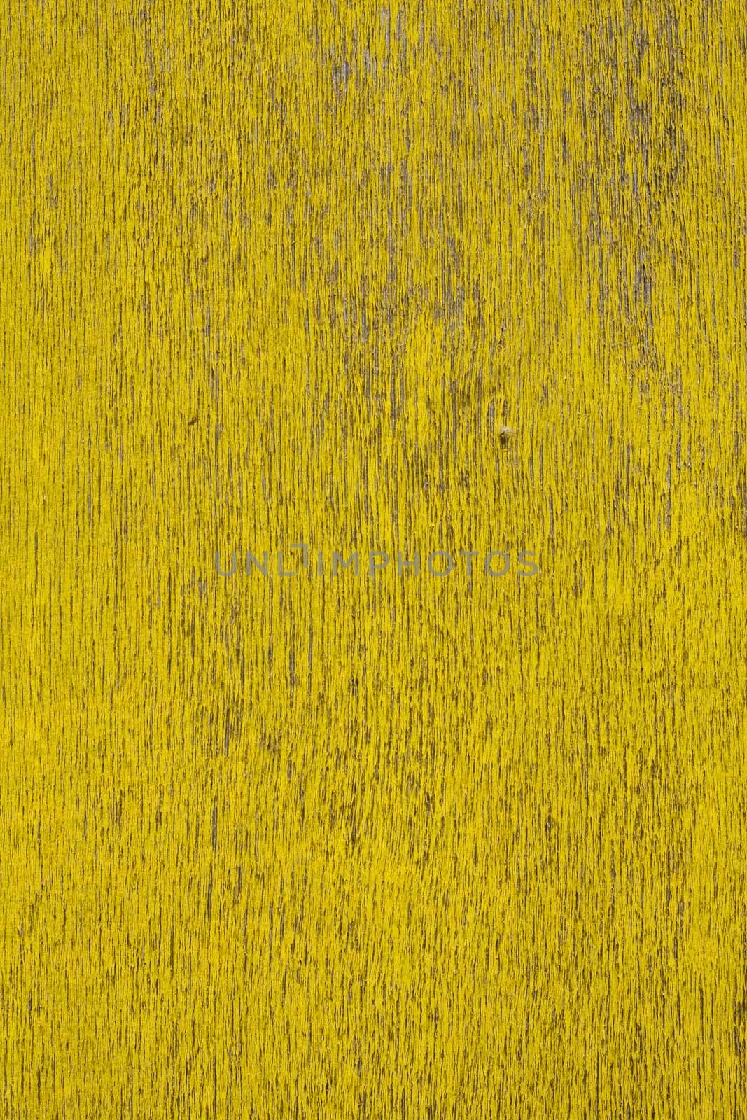 Close up view of a peeled yellow wooden textured wall.