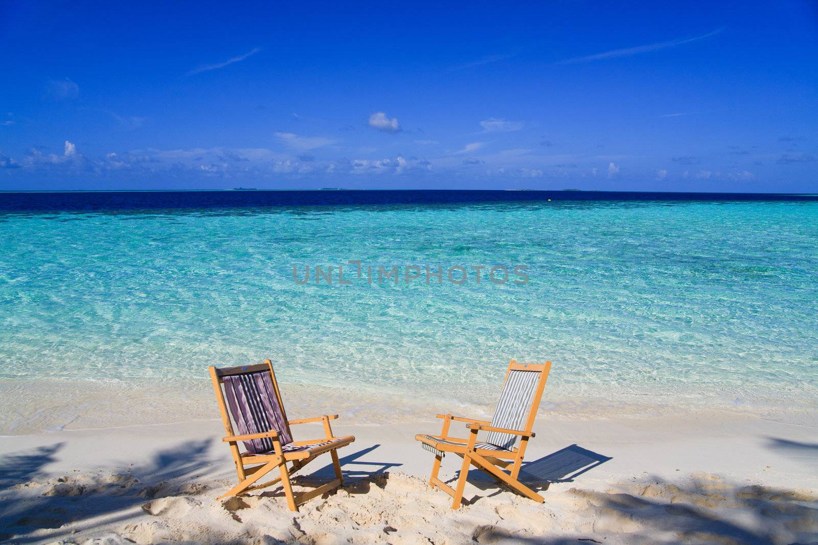 Relaxing on tropical paradise with white sand at Maldives and green palms with blue sky