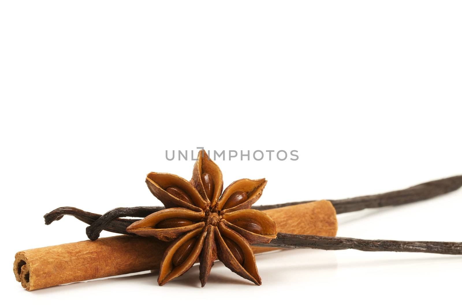 cinnamon stick, star anise and two vanilla beans on white background