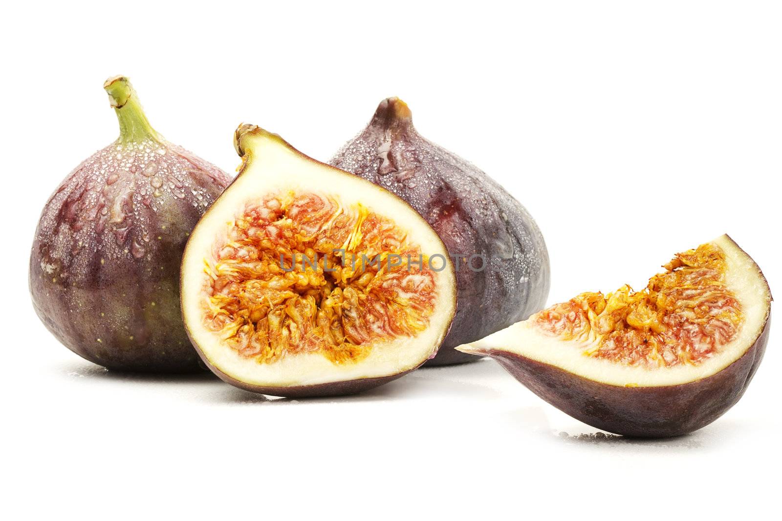 two wet figs and a half and a fig wedge on white background