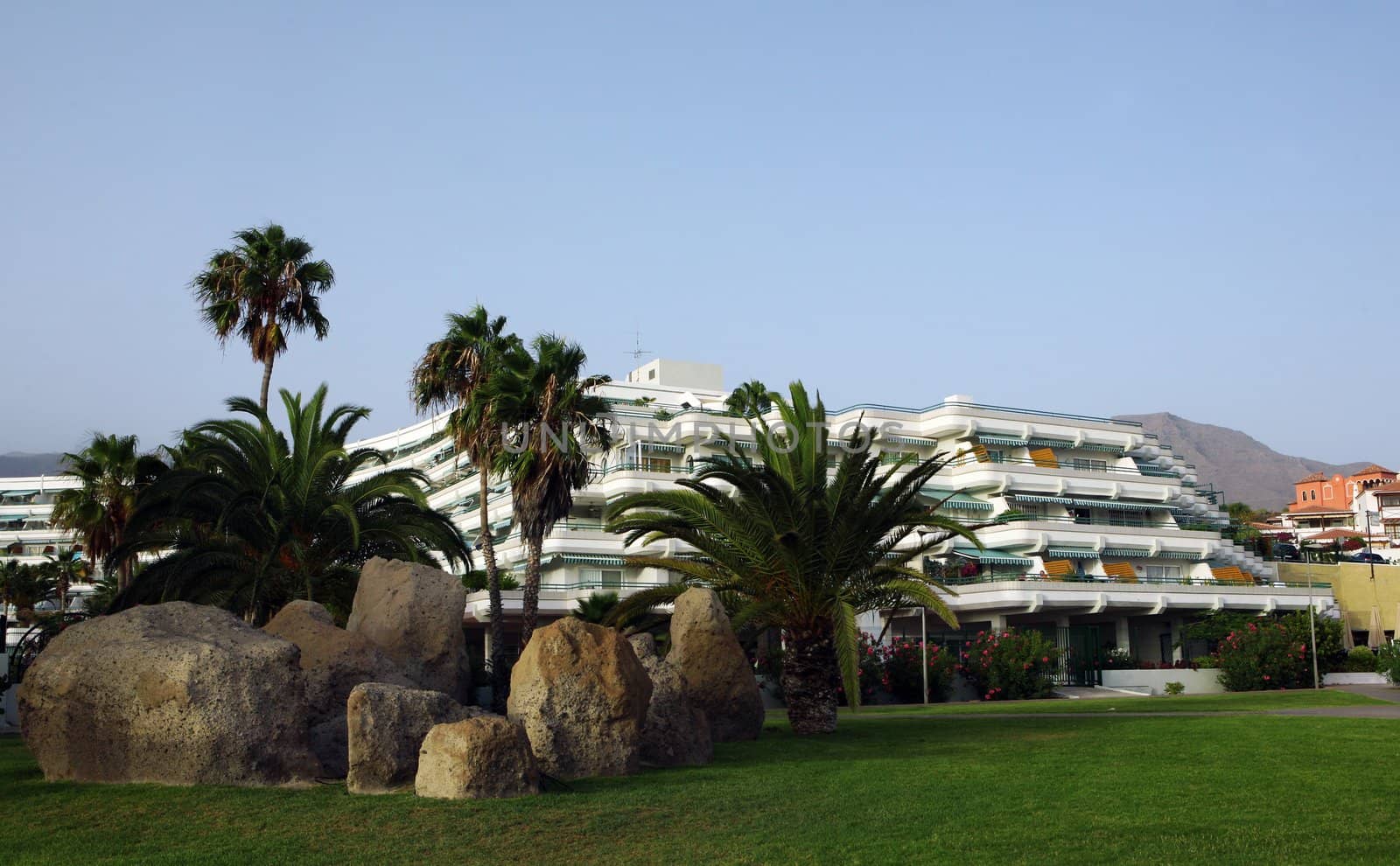 Big hotel with palms and stones around on Costa Adeje, Tenerife