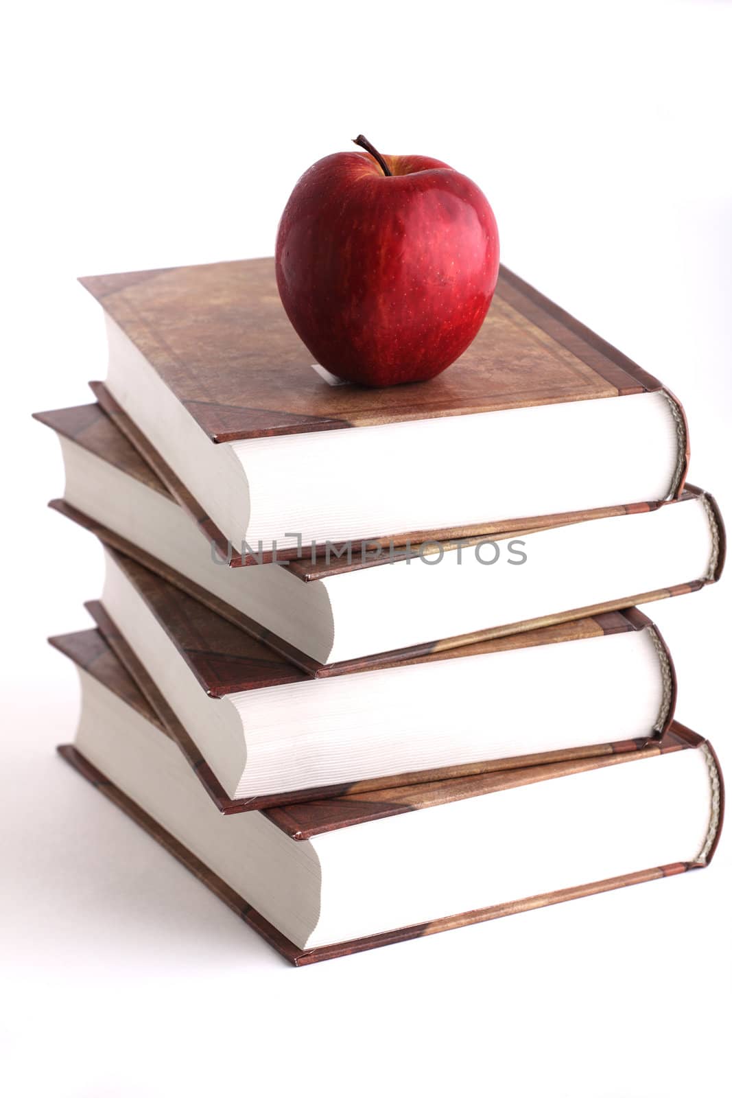 Red apple on the stack of the books by Aevathari