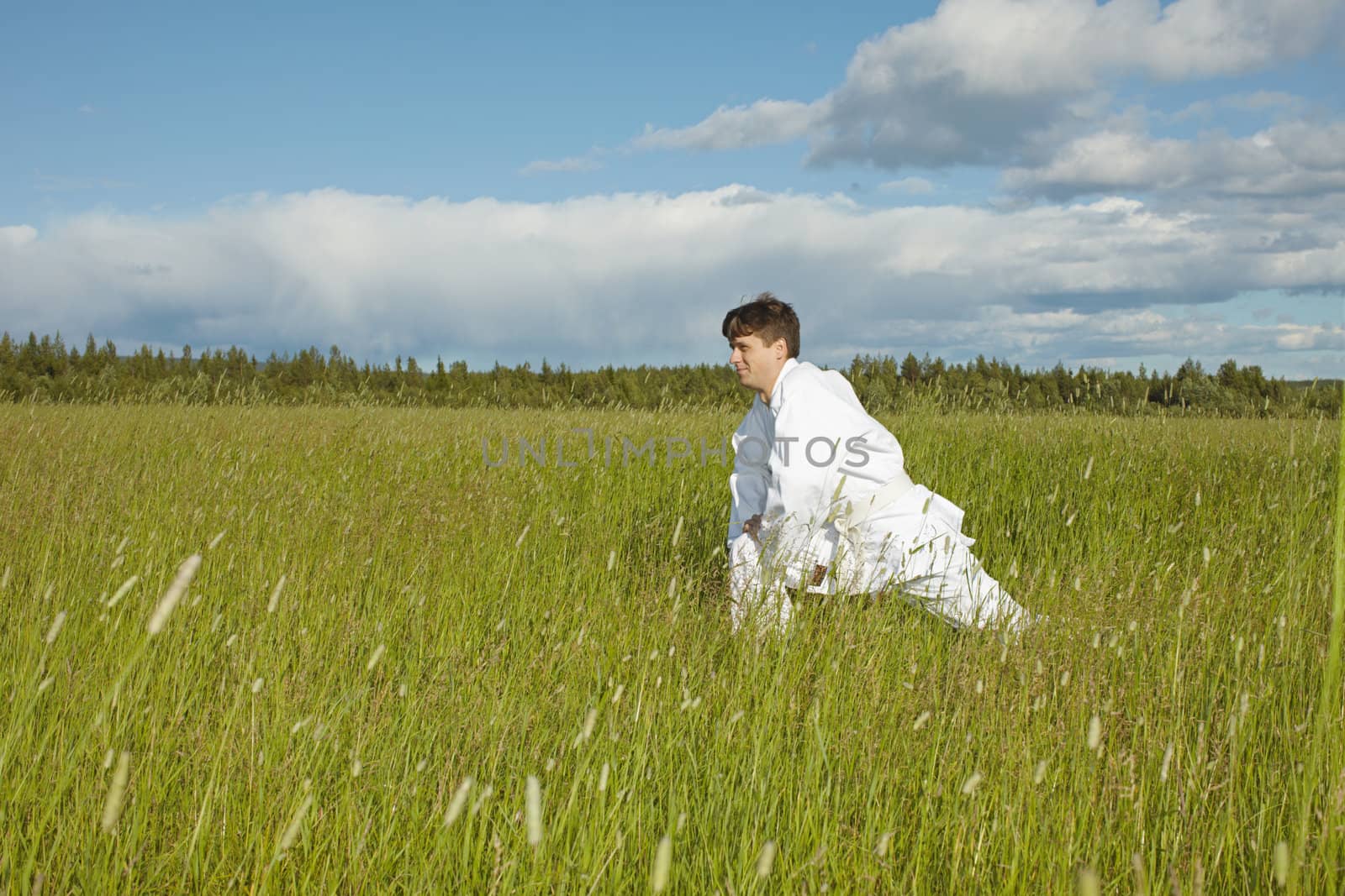 Man does exercises in the summer field