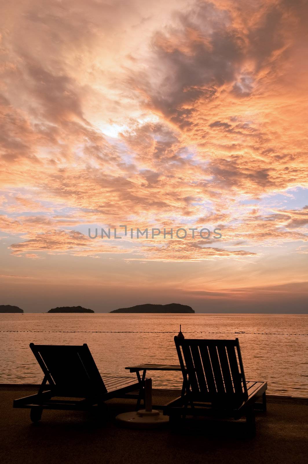 Silhouette of two relaxing seats at seashore