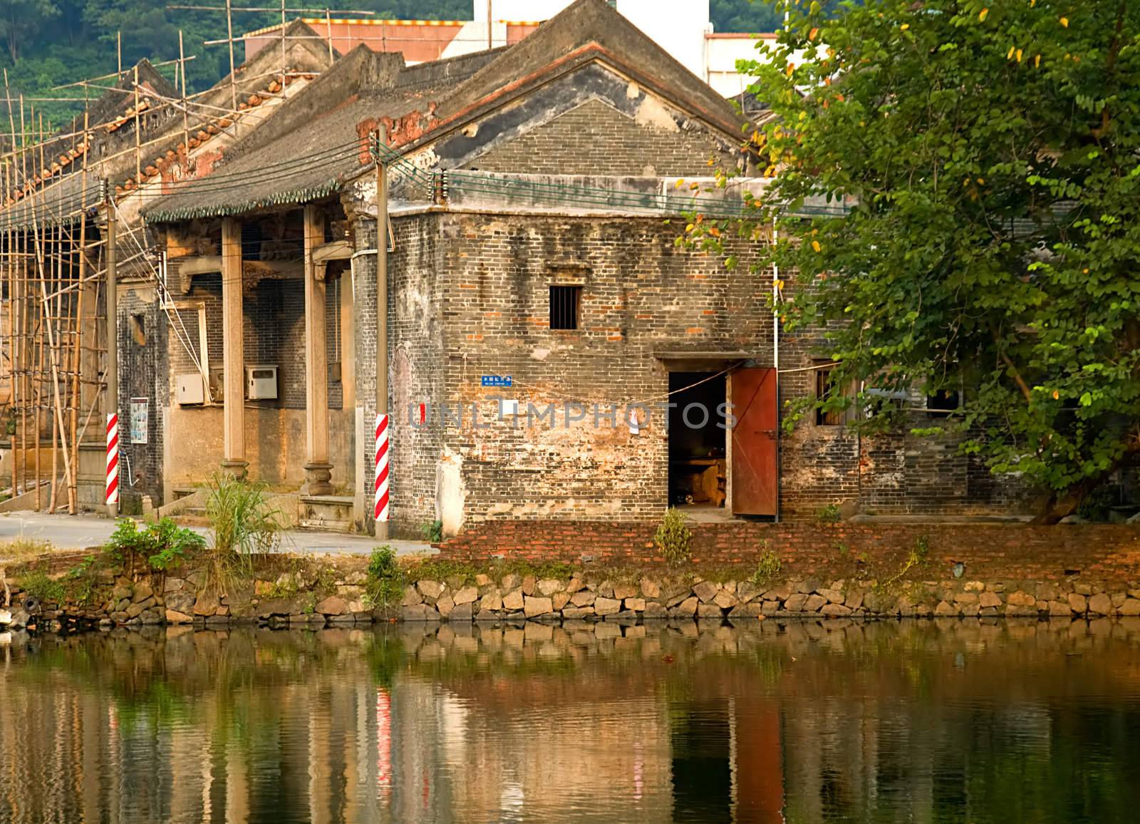 The old house construction in a village of China, with reflection over lake