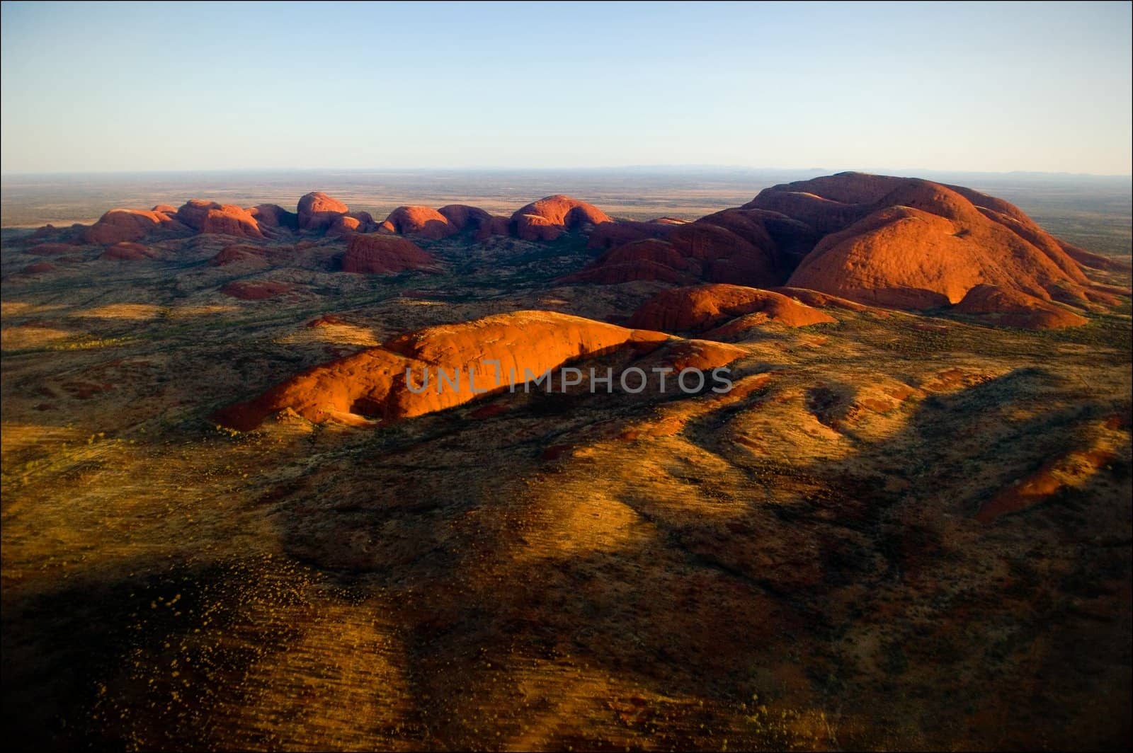 The highest monolith, Mount Olga in brightly red color of the coming sun.