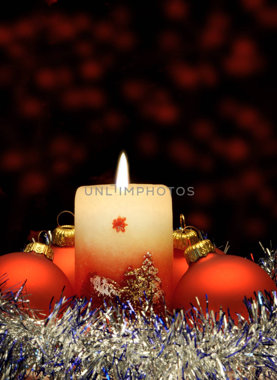 Christmas candle and red spheres. A celebratory composition