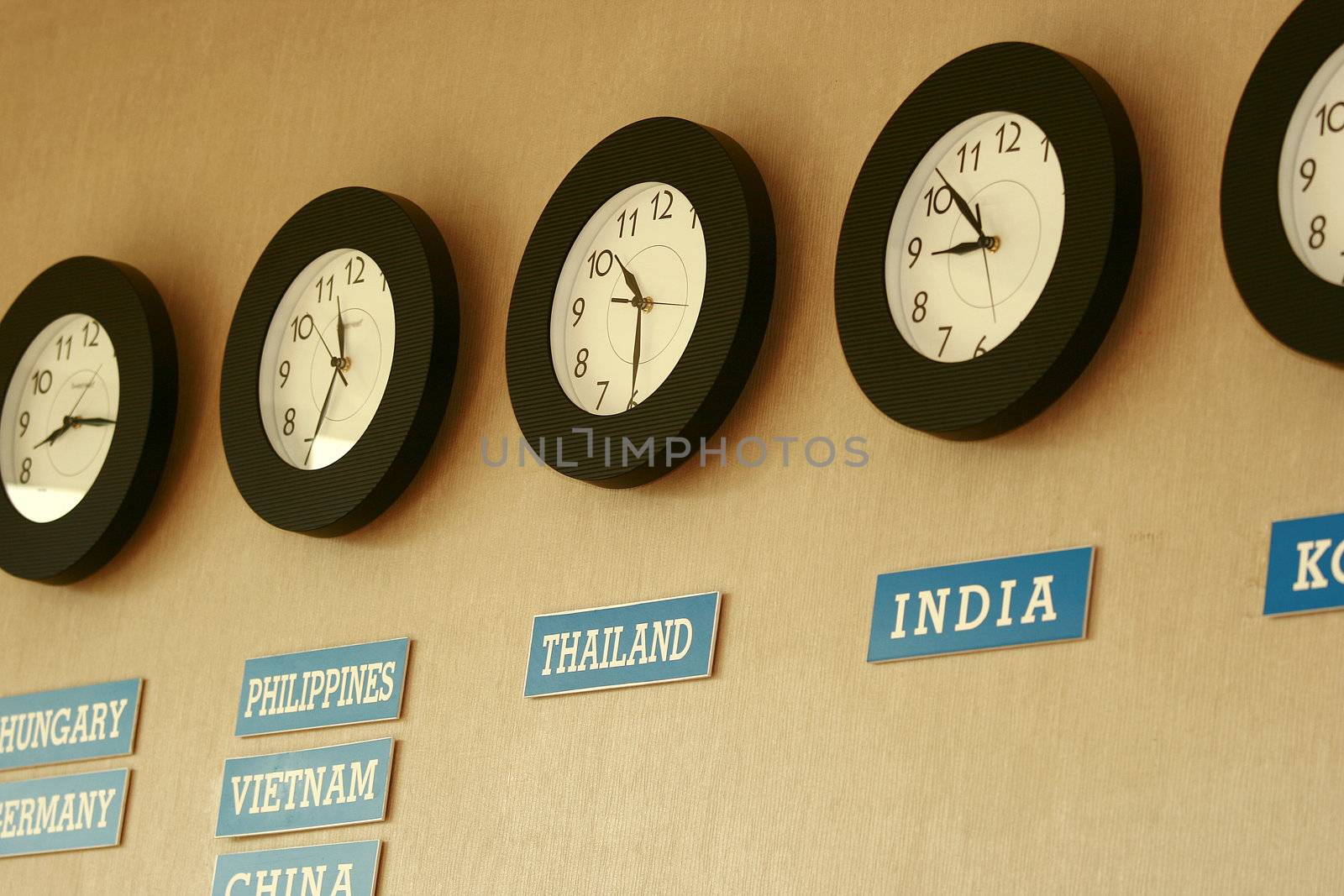 clocks on a wall with time zone of different country