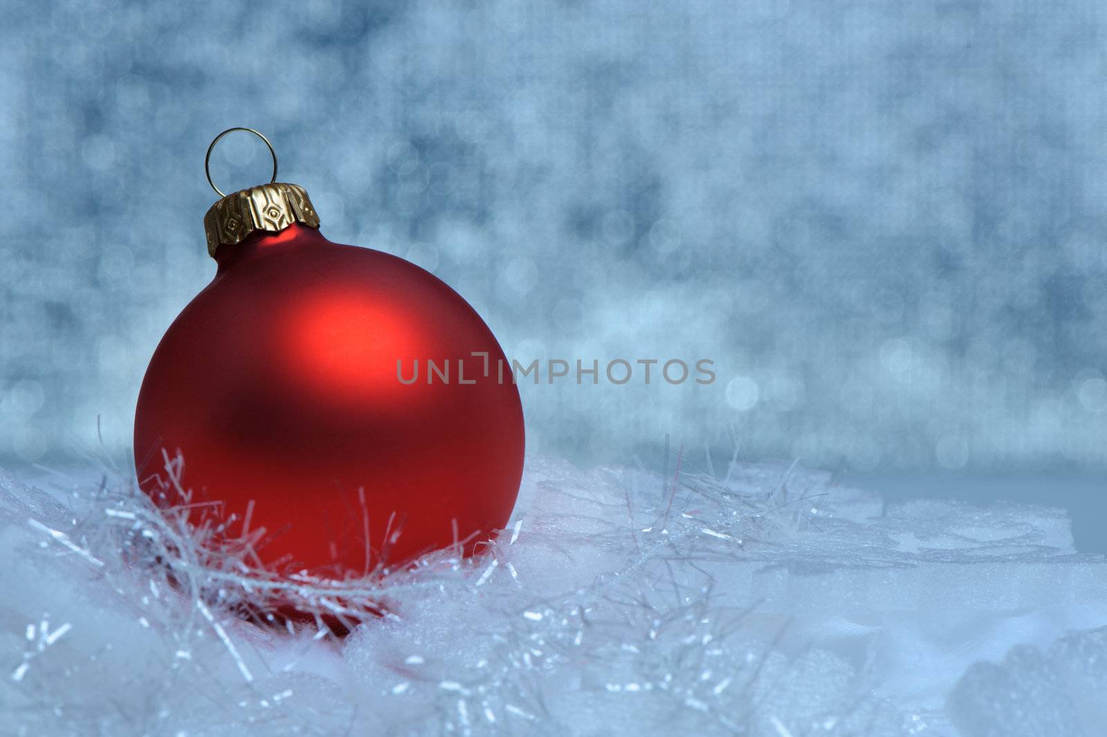 Christmas red sphere. Bokeh background blue toned