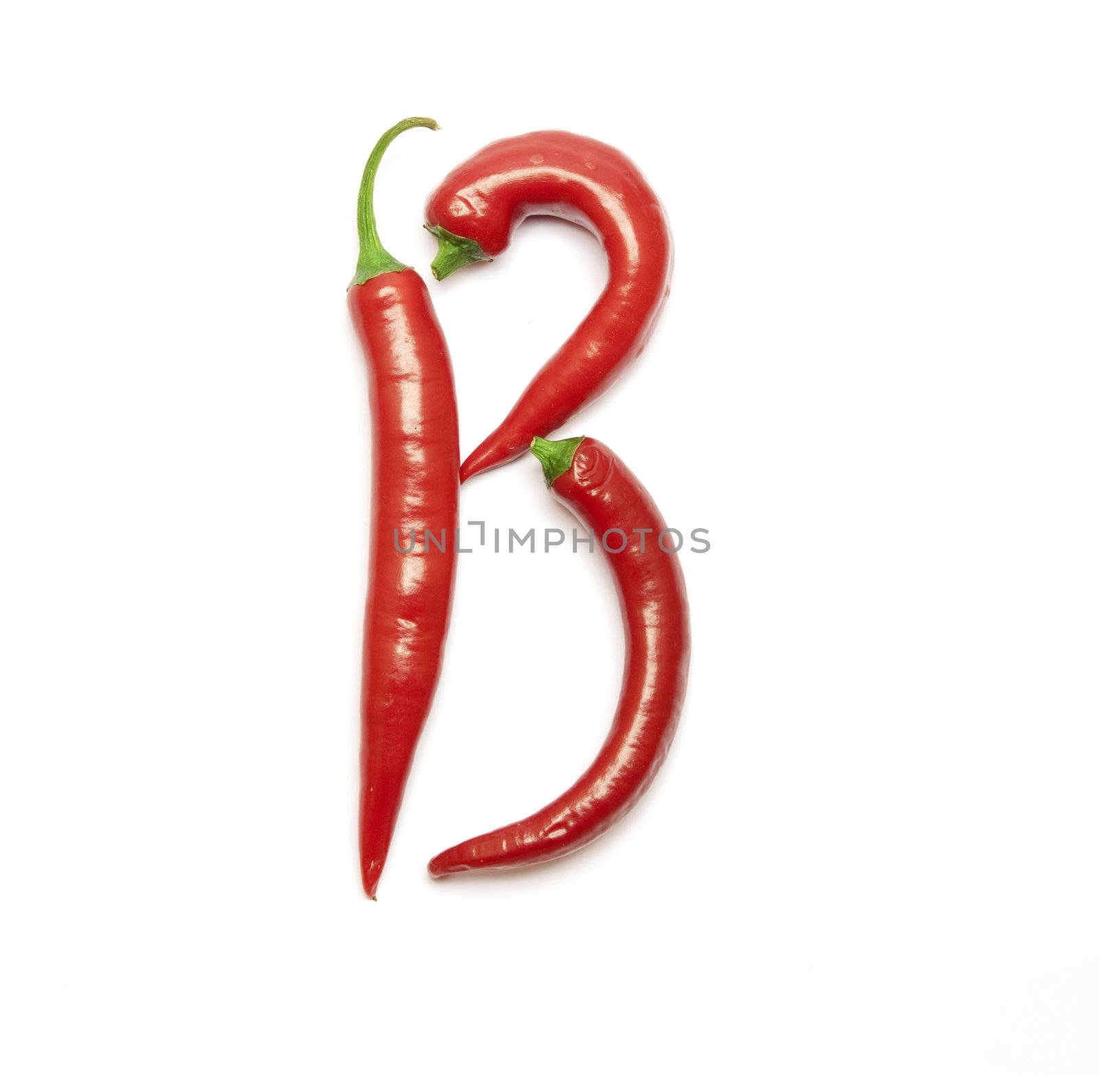 Letter made from red peppers over white backround