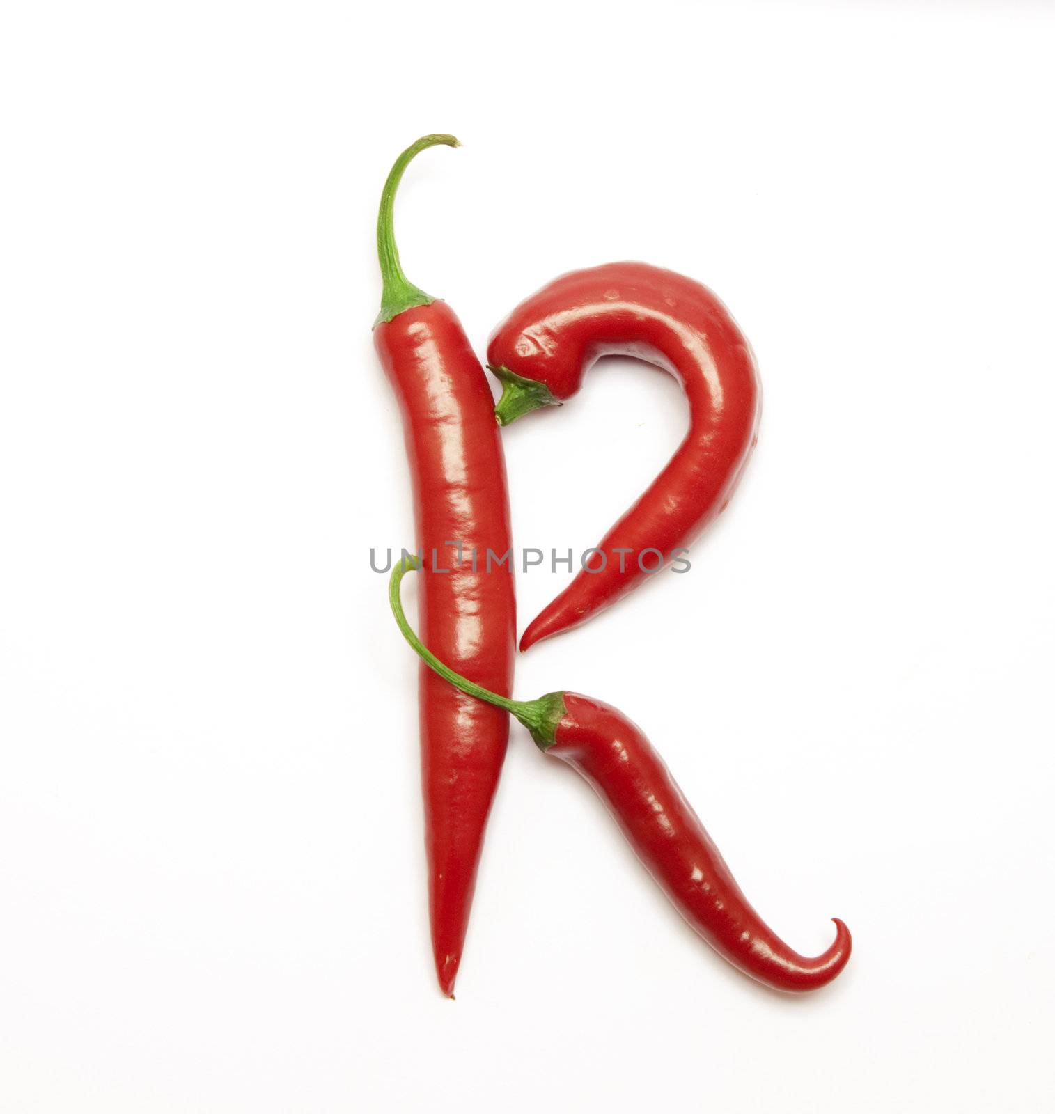 Letter made from red peppers over white backround