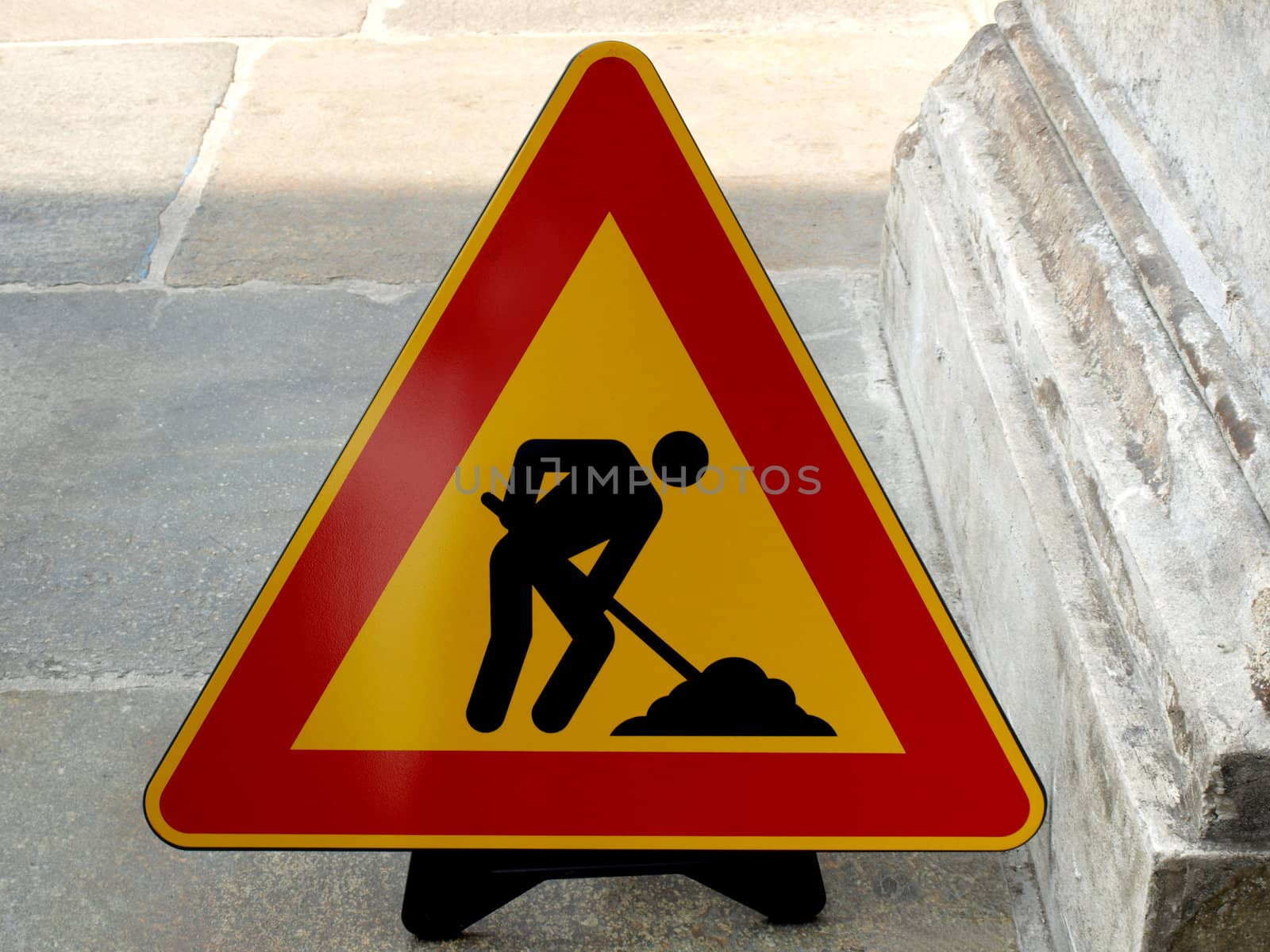 Road work sign on a sidewalk pavement