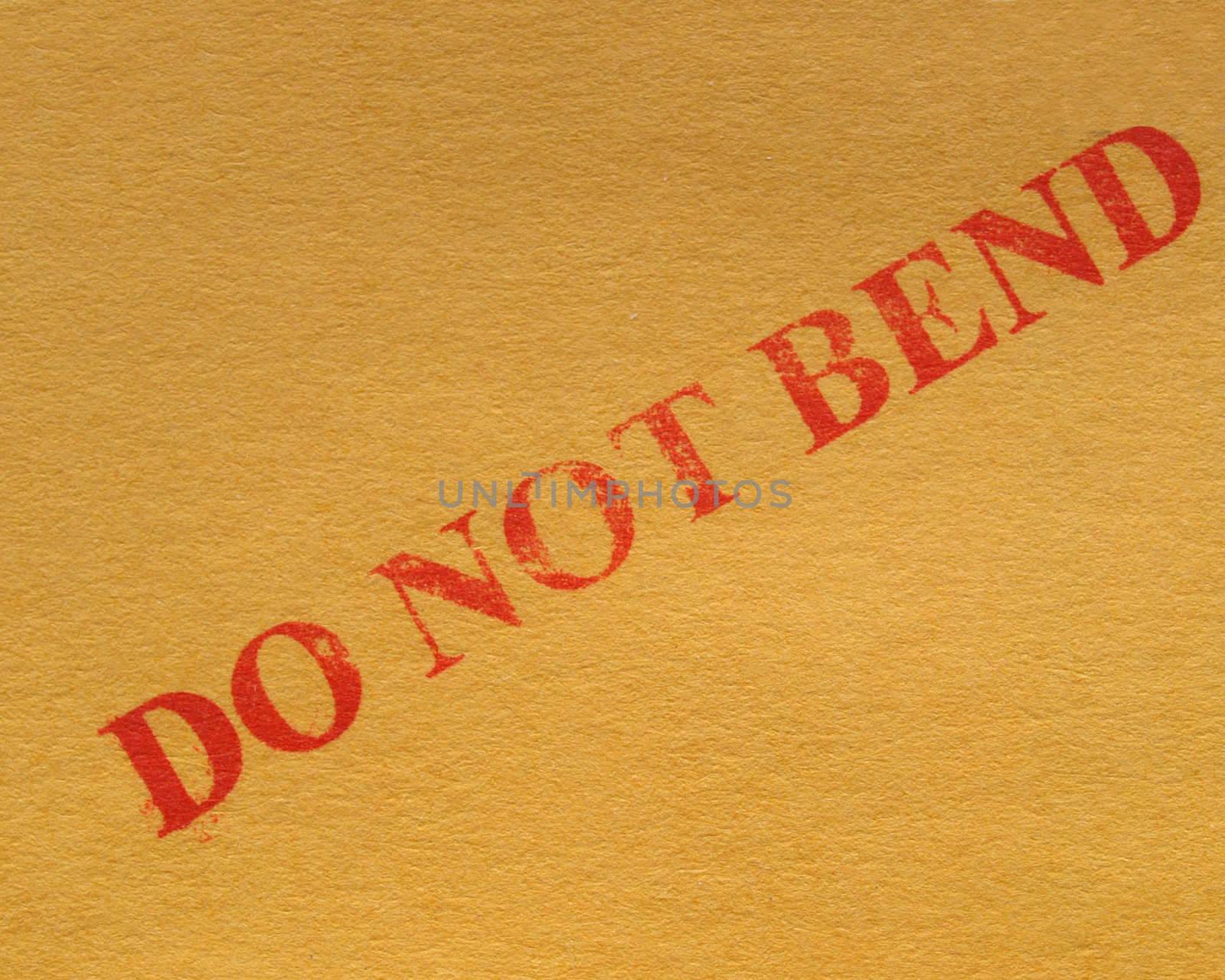 do not bend - red ink warning over a brown cardboard box