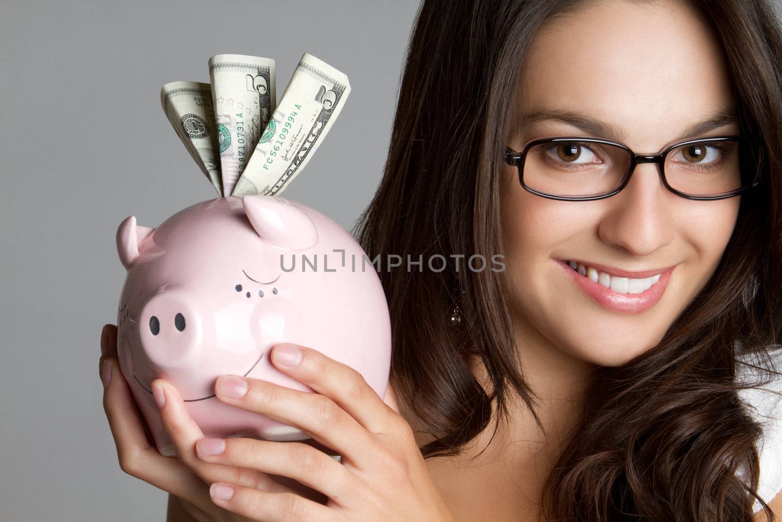 Smiling girl holding piggy bank money