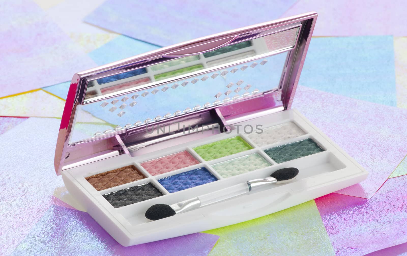 Eye shadow kit over colourful papaers background