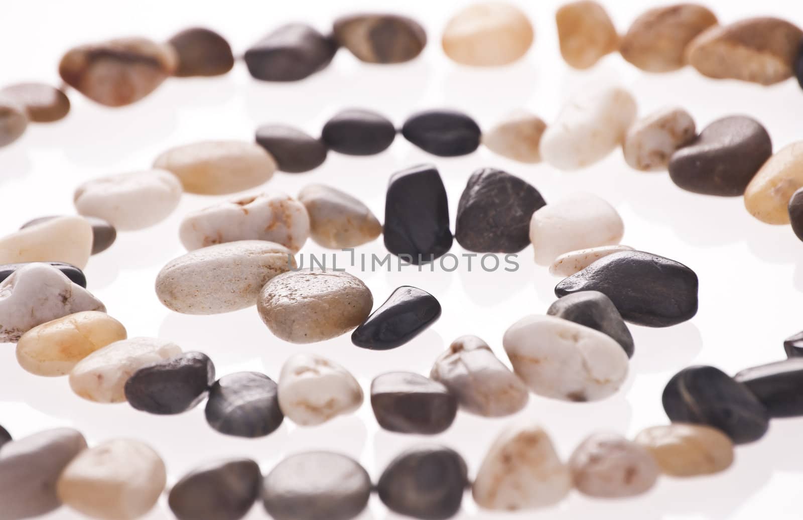 Stone spiral made from the beach pebbles isolated on the white