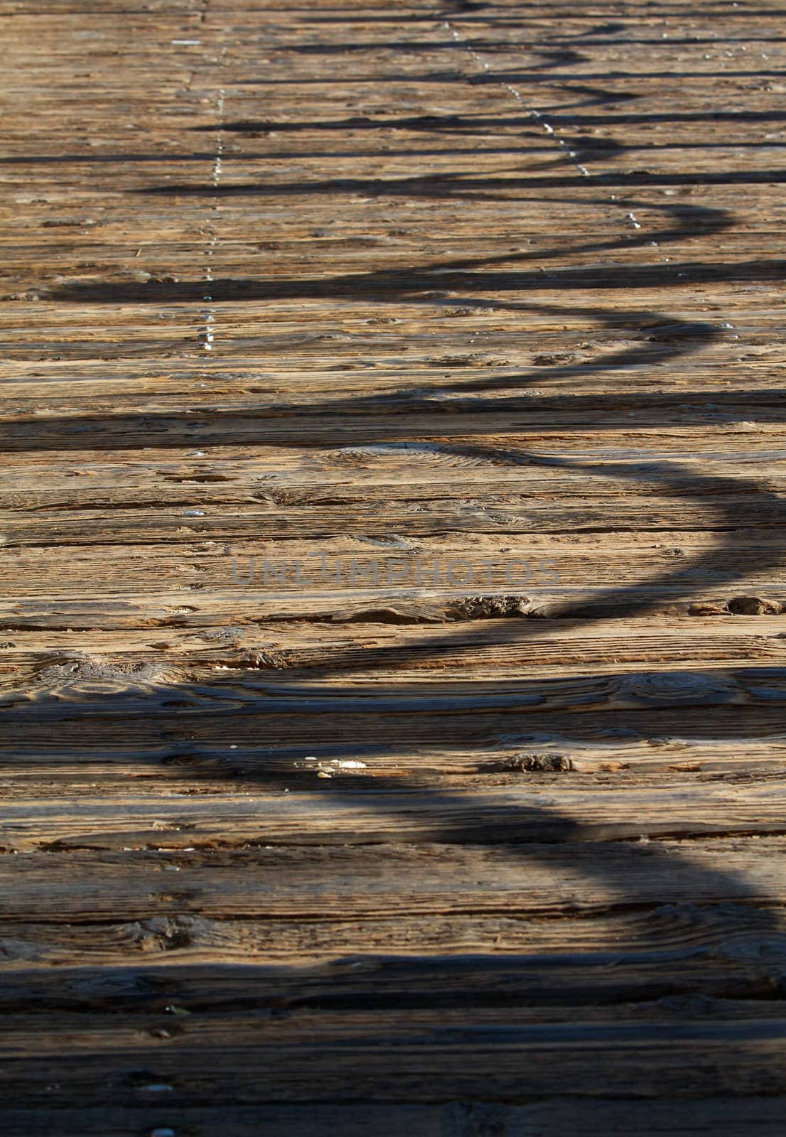 Old wood boardwalk or sidewalk with shadow of rope barrierz