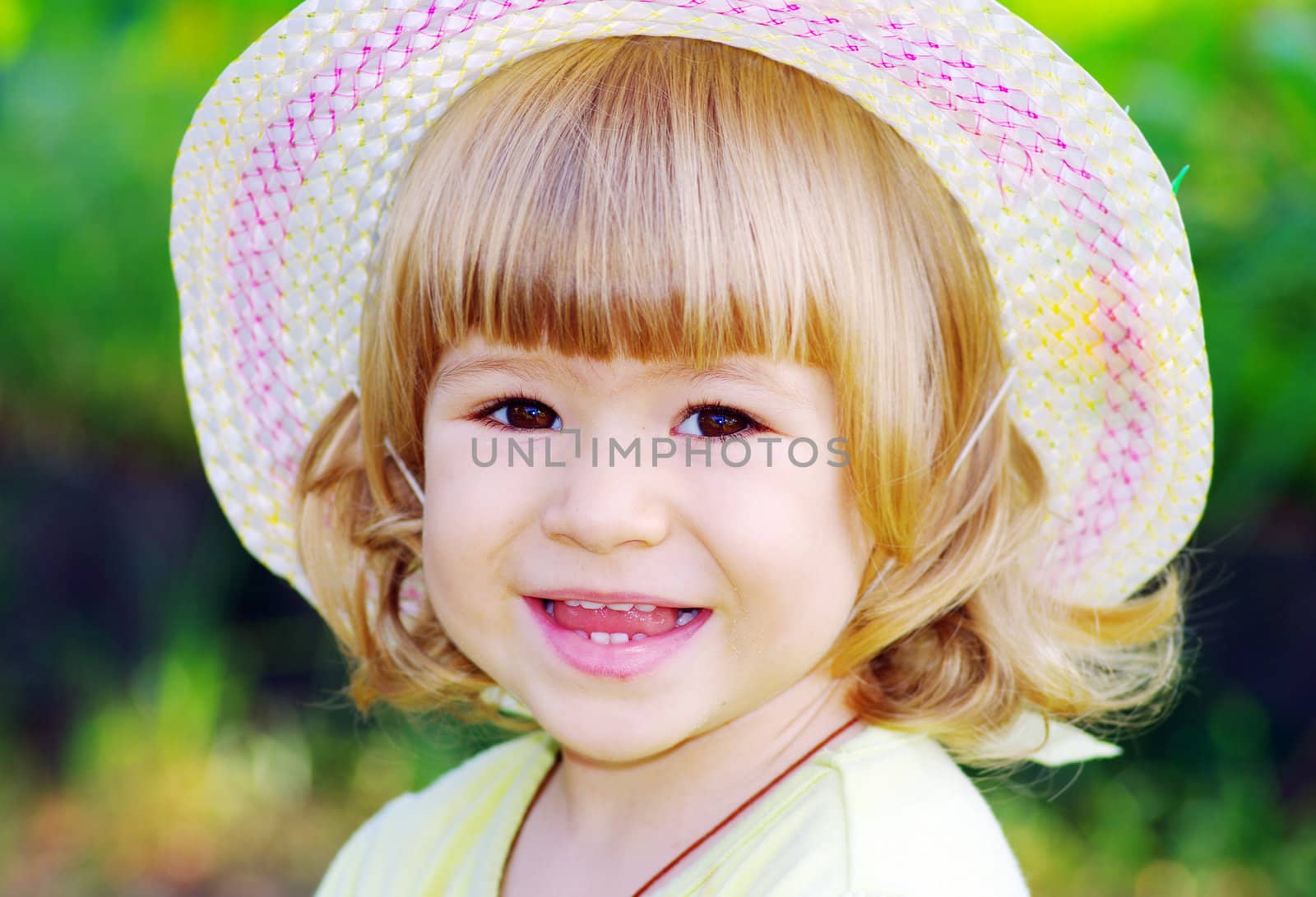 Smiling girl on the meadow looking right at camera  by dolnikow
