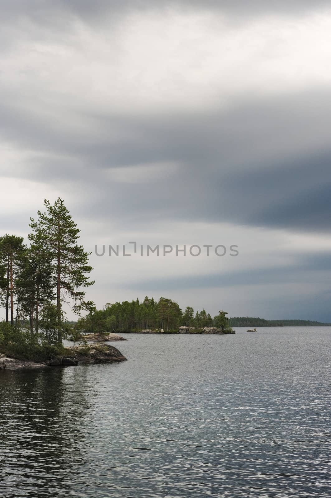 Rocky coast of lake under the cloudy sky