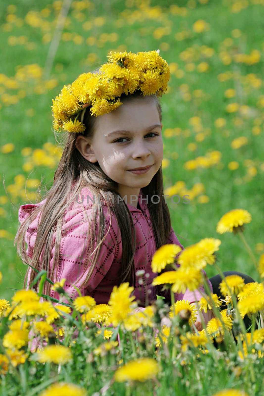 Nice, young girl enjoy summer time in the dandelion meadow.