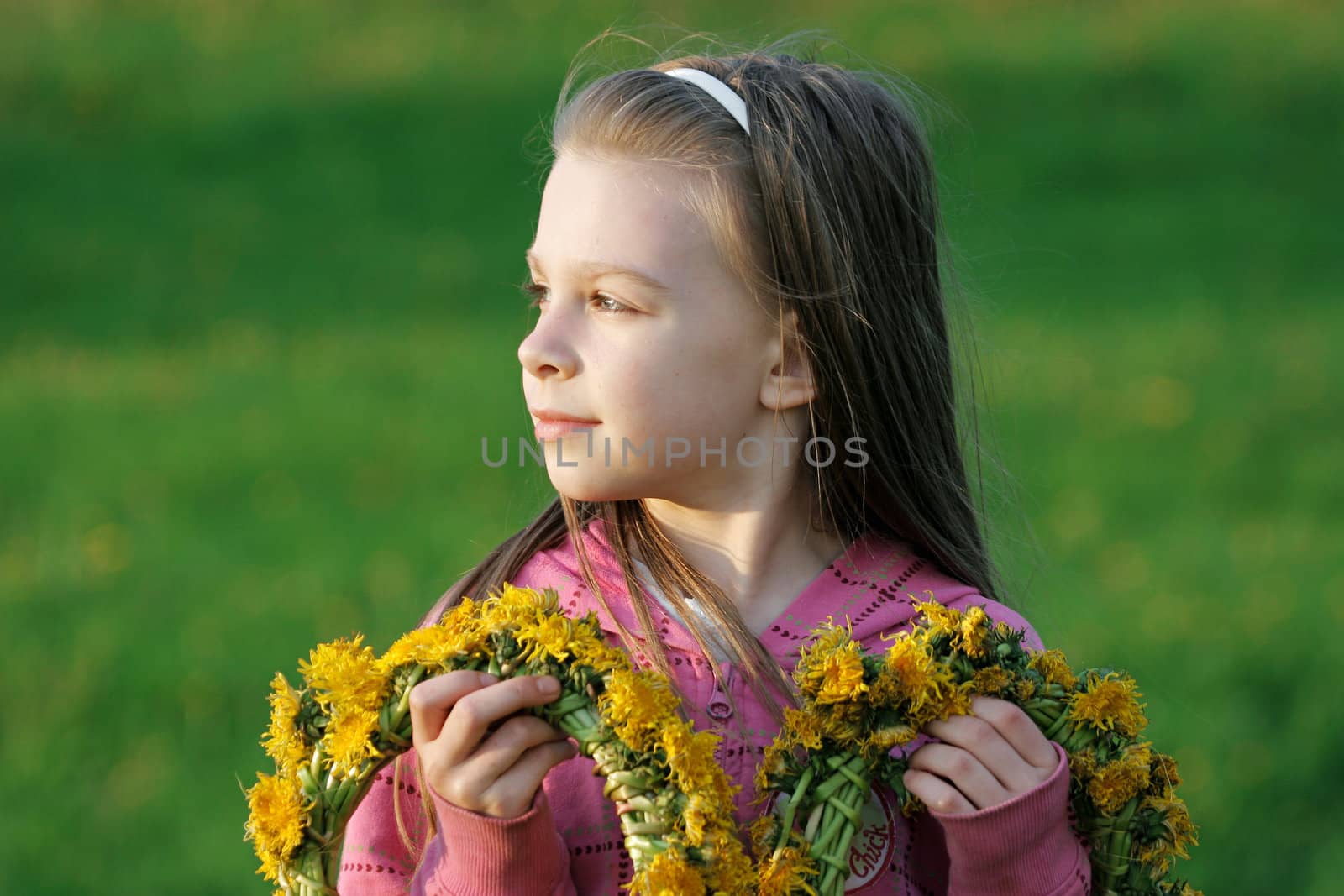 Nice, young girl enjoy summer time in the dandelion meadow.