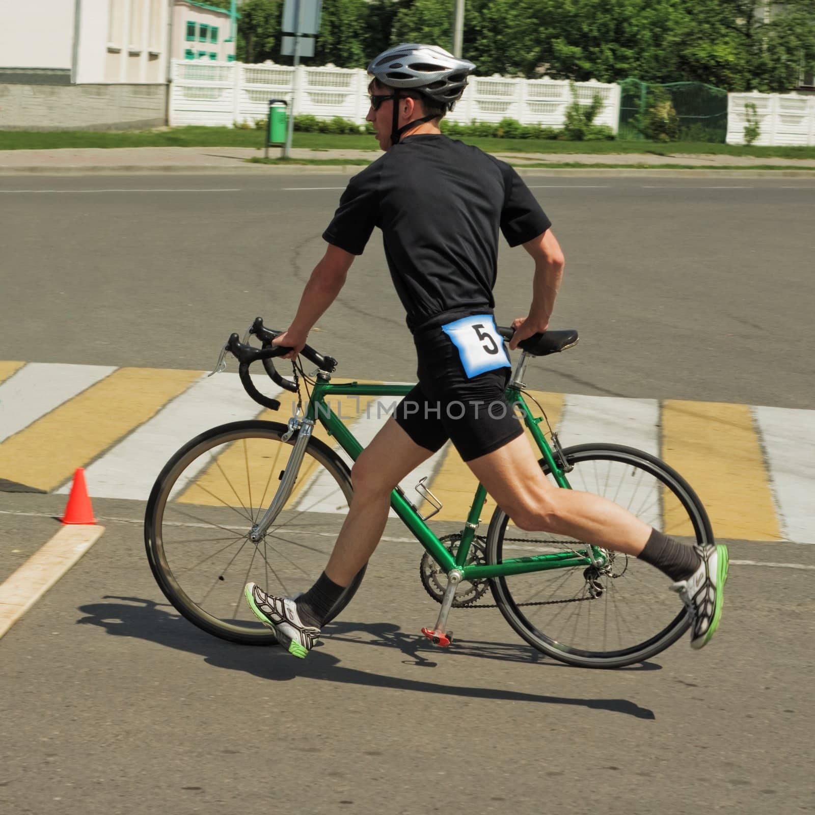 The sportsman running near  bicycle on road