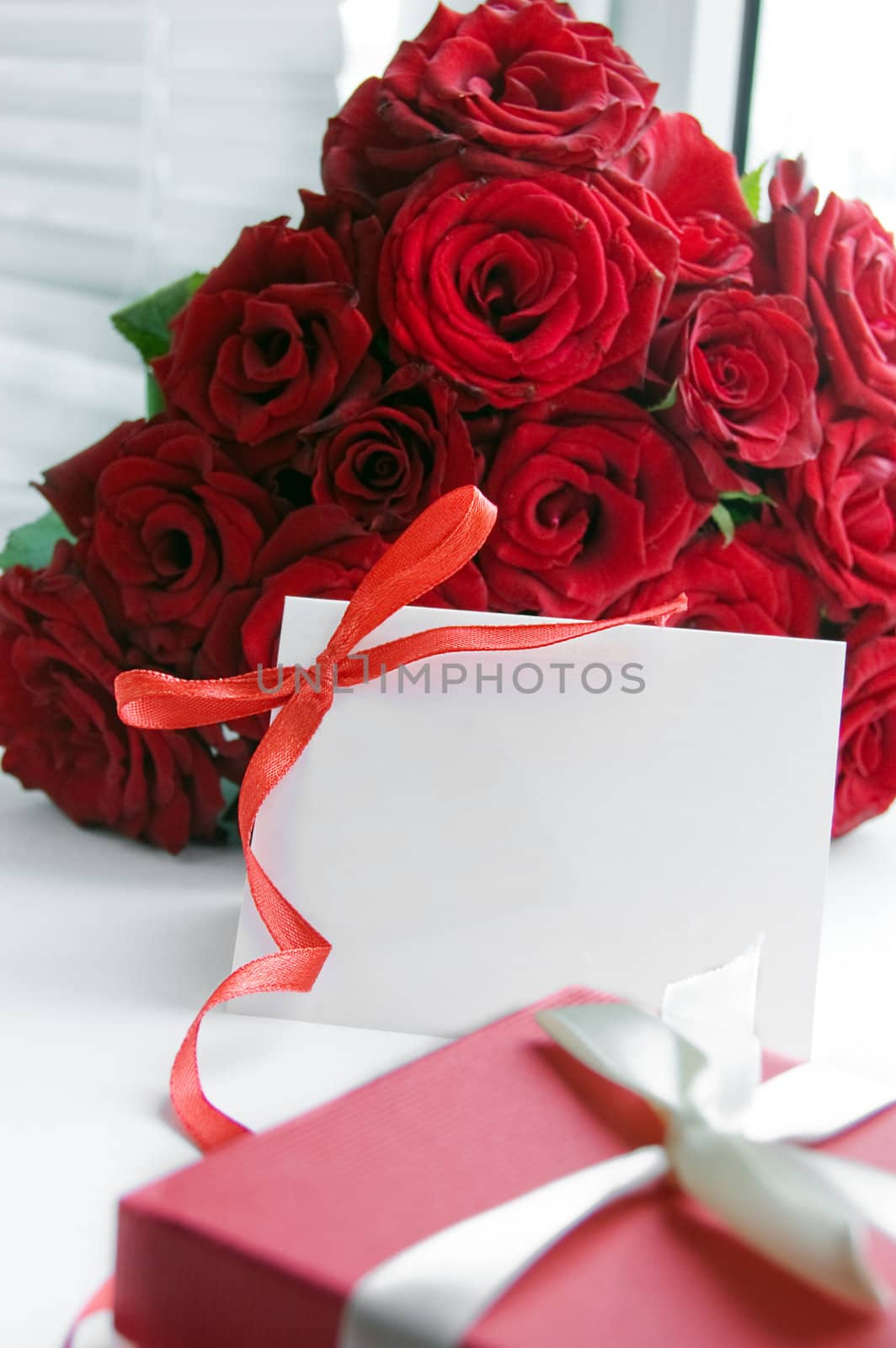 Blank note for message over bunch of red roses
