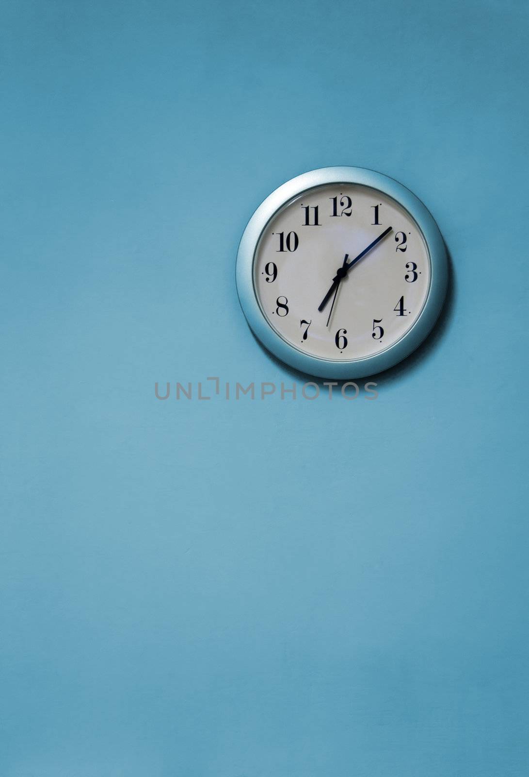 A blue and white clock on a blue wall