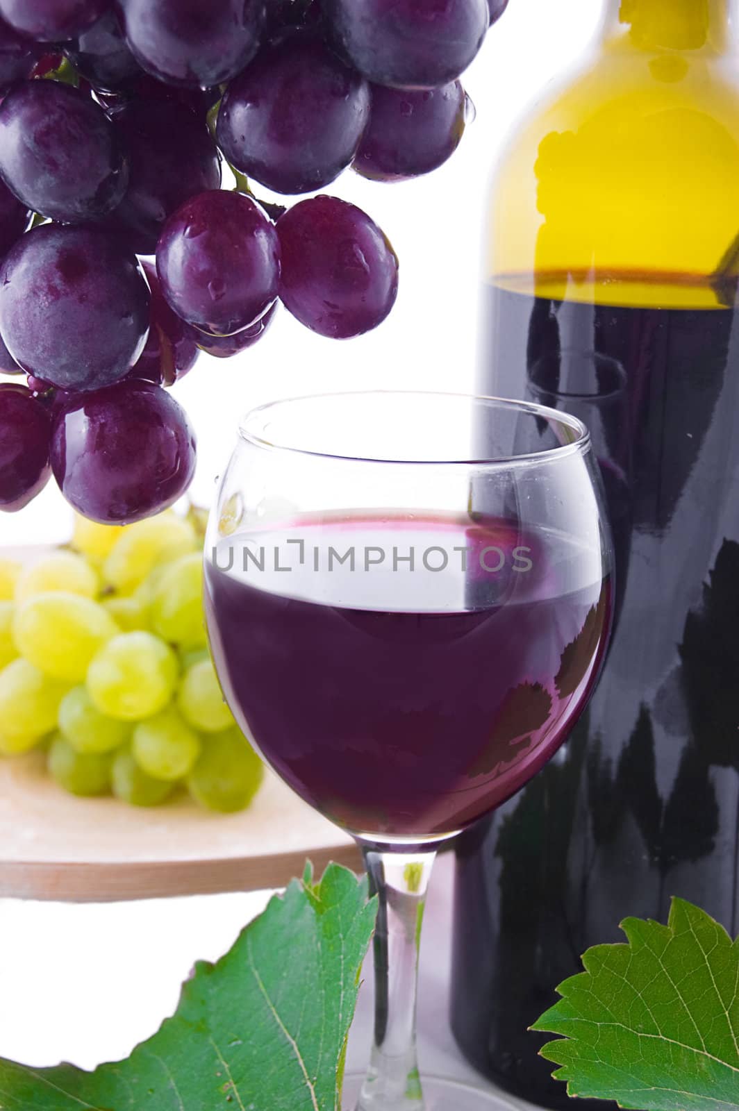 Red wine bottle, glass and cask with grapes over white