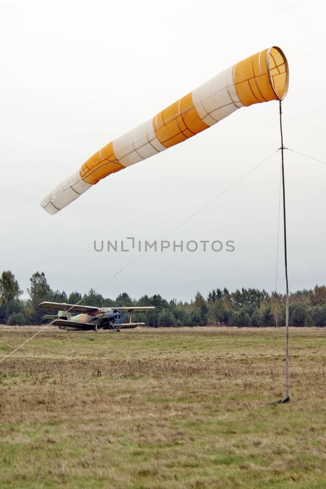 The biplane before flight on airfield  - in the foreground a wind directional marker
