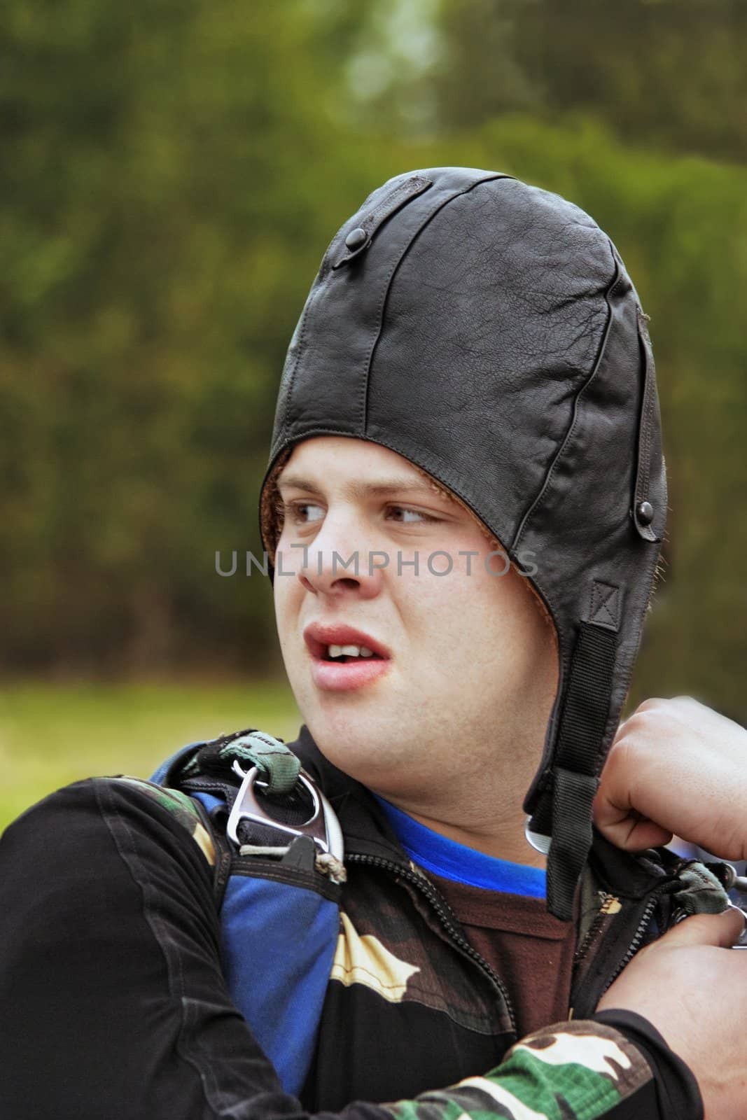 The parachutist in helmet prepares for a jump - checks parachute belts
