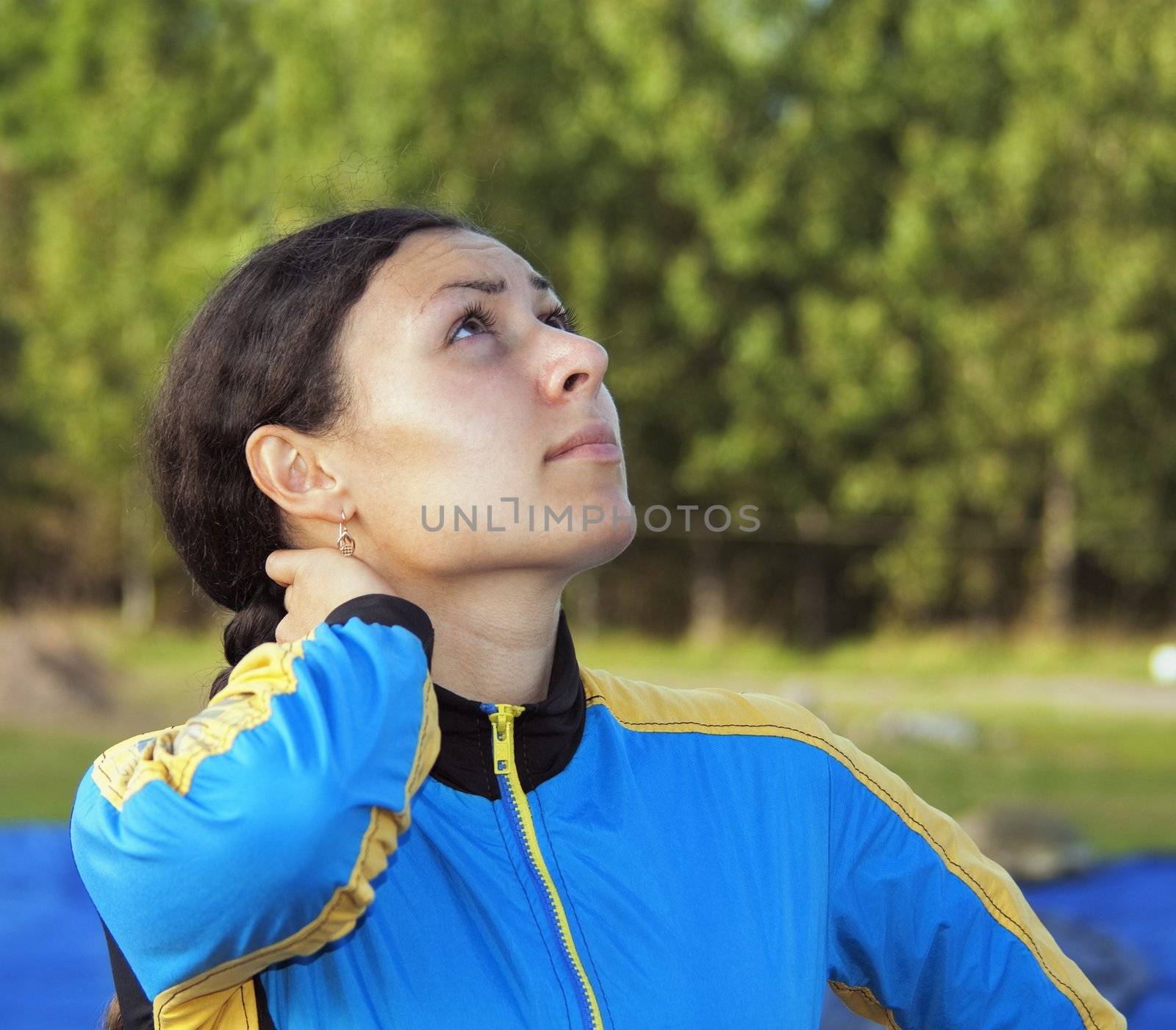 The girl in blue overalls looks in the sky at girlfriends-parachutists