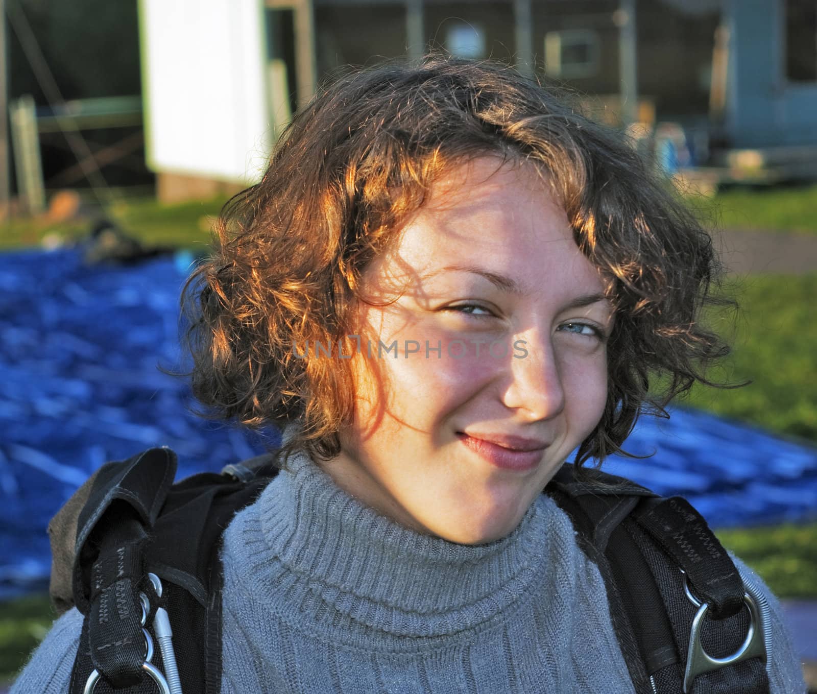 The smile girl-parachutist in a grey sweater