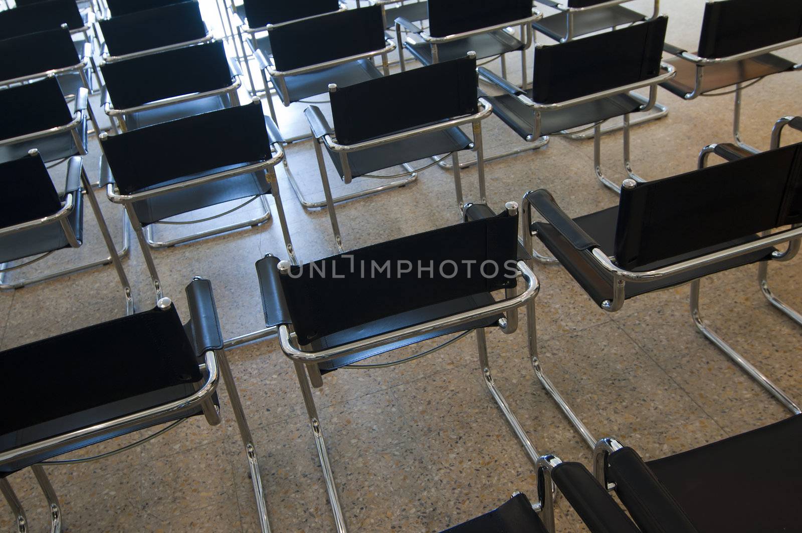 Many contemporary black chairs in a room