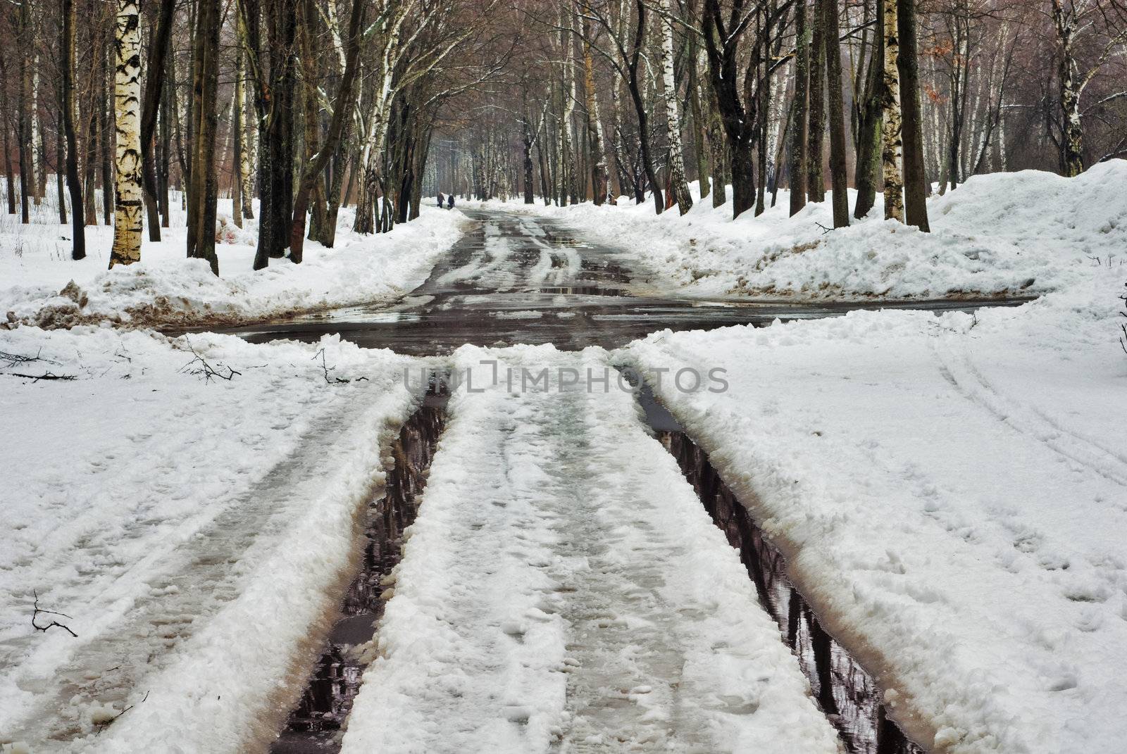 Spring crossroads of road  - the track is filled in by water from thawing snow