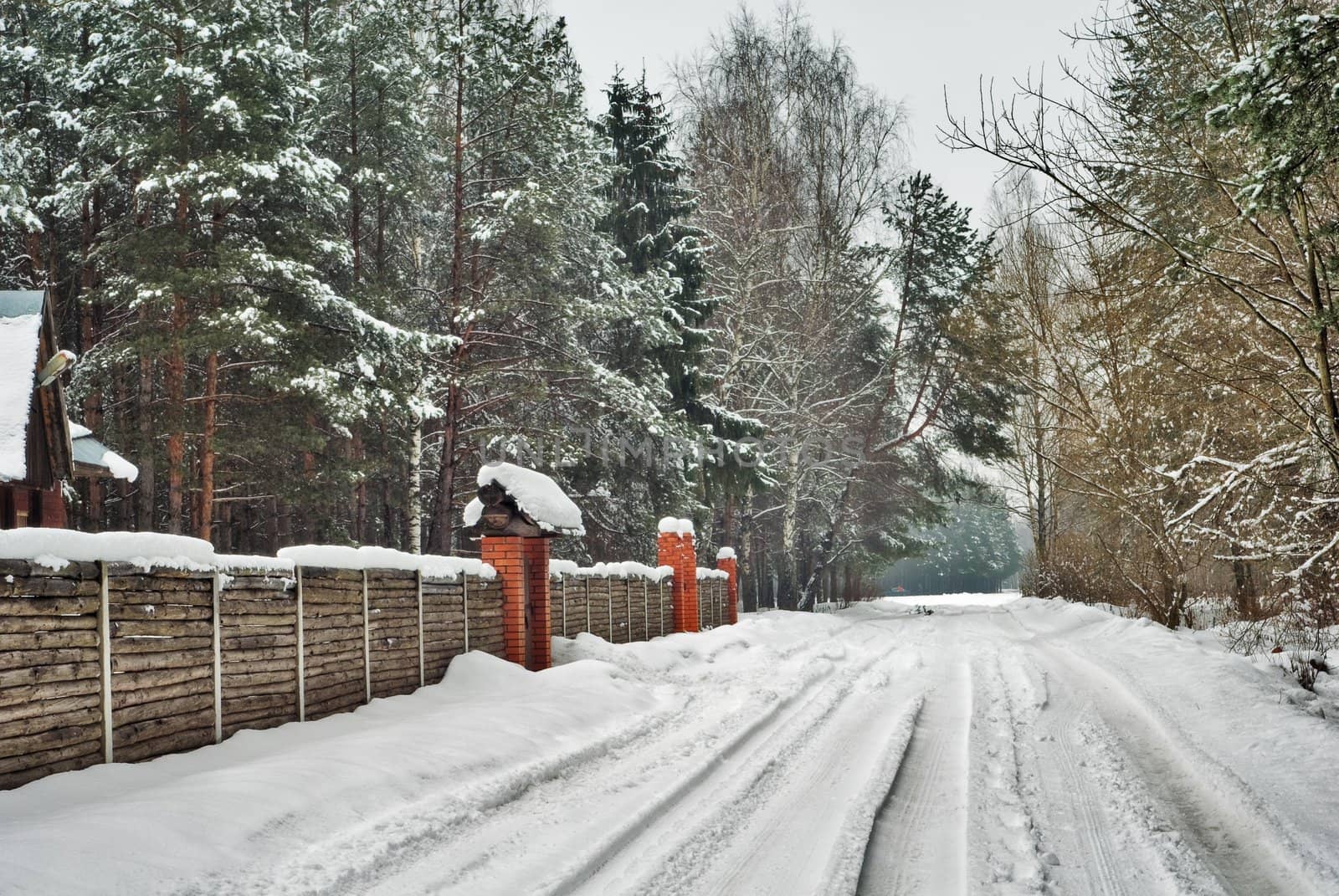 winter house with fence and snow road