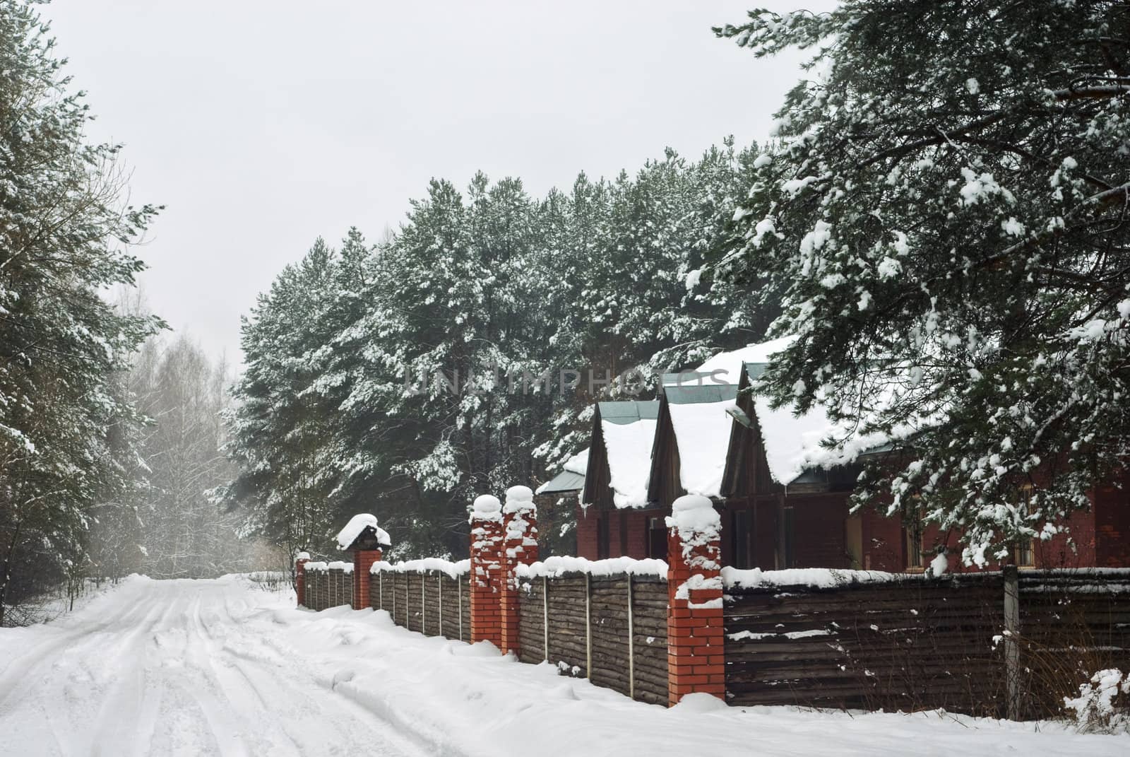 winter house with fence and snow road