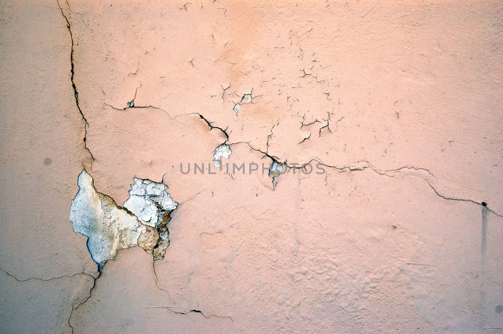 A cracked light pink grunge concrete background