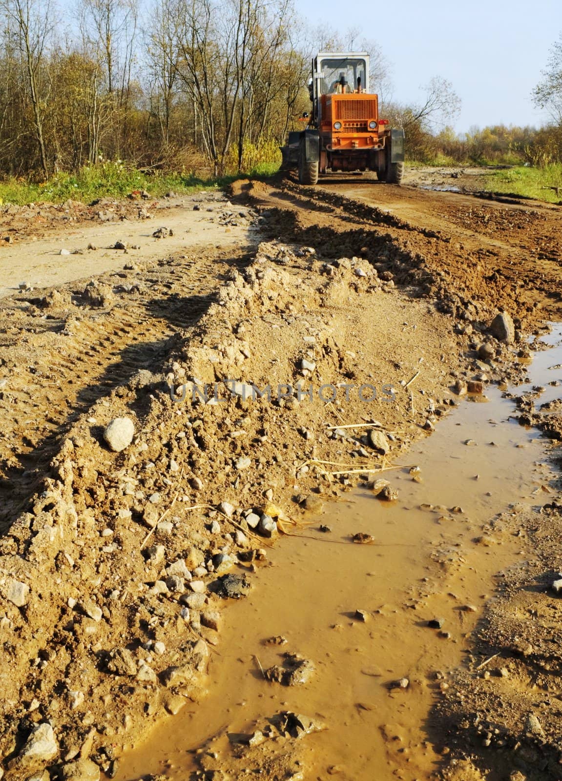 The grader levels gravel at road building